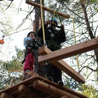 Mies ja lapsi tasanteella tulossa palkkiesteelle Seikkailupuisto Korkeessa