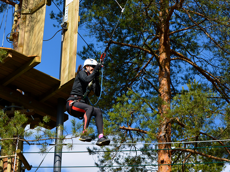 Seikkailija Tarzan-hypyn ilmalennossa Seikkailupuisto Huipussa